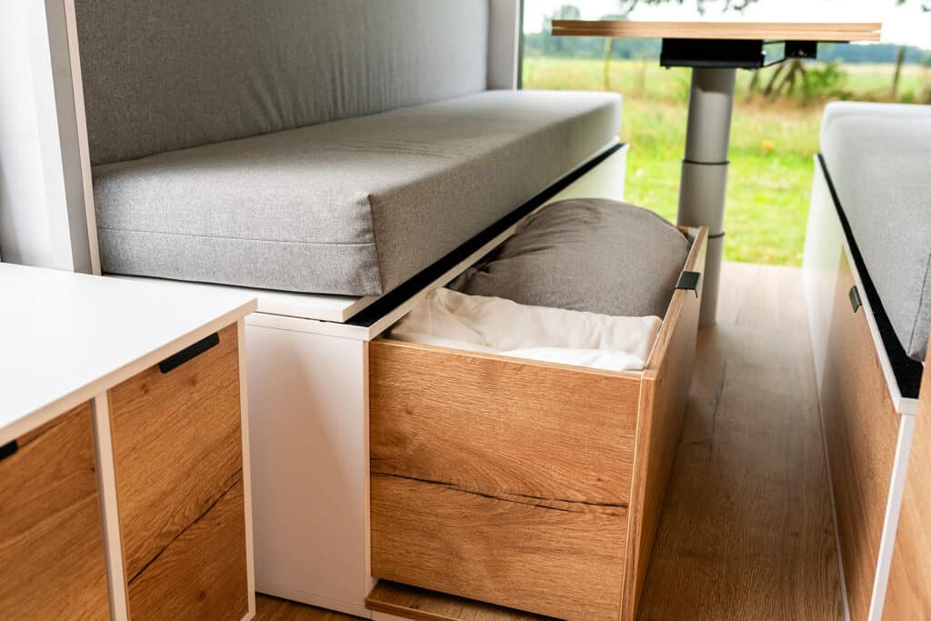 Bedding storage area under the benches in The Biggie campervan