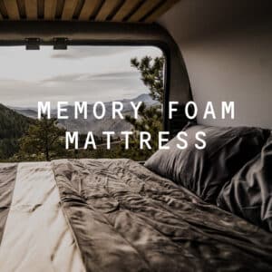 Memory foam mattress in the OG Campervan overlooking a mountain range.